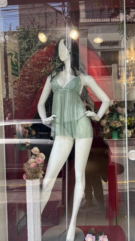 Maniquí de verde tras el vidrio